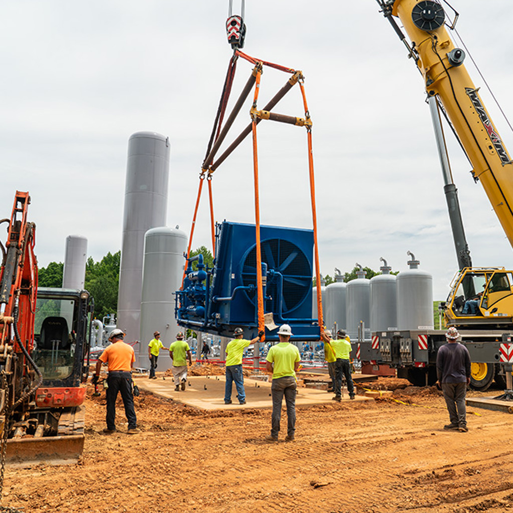 millwright and rigging specialists setting compressor