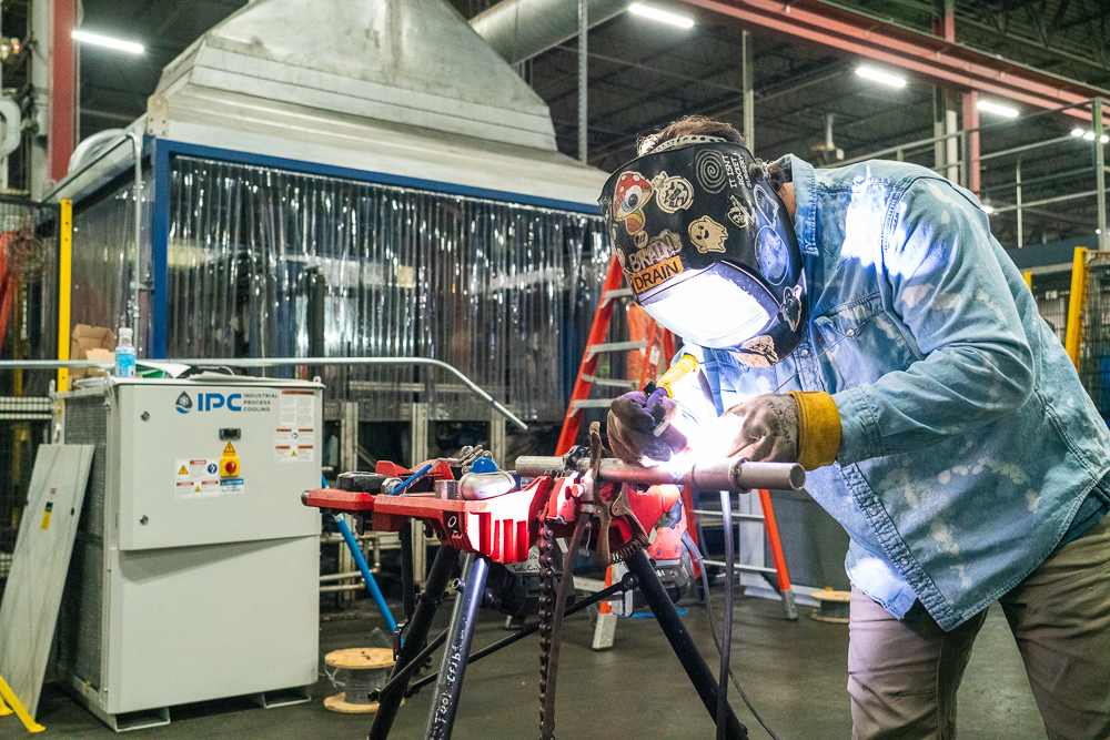 JDI Industrial Contractor Services welder installing piping for robotic assembly