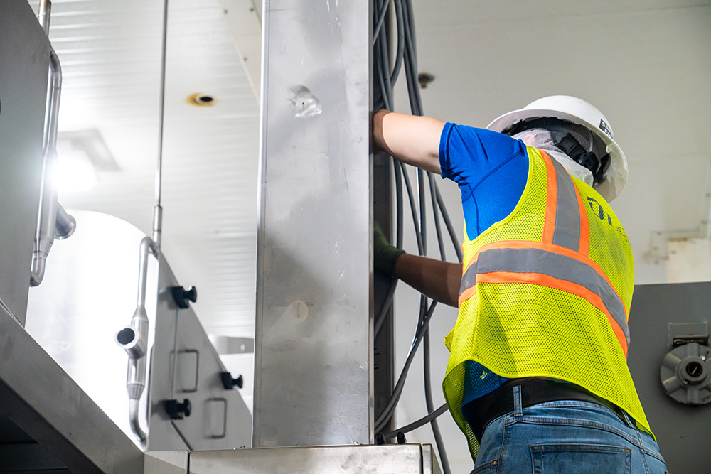 Industrial Electrician Wyatt installing cables for electrical project at US Waffle